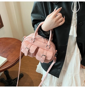Détail du sac Boston en cuir ciré rose avec des poches et des ferrures argentées