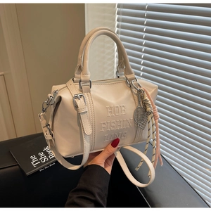 Creamy white bowling bag featuring embossed text and a tennis racket charm detail