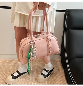 Détail du sac bowling en cuir rose avec fermeture éclair argentée et breloque ours