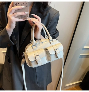 Détail du sac Boston en cuir ciré crème avec poches à boucles et bandoulière amovible