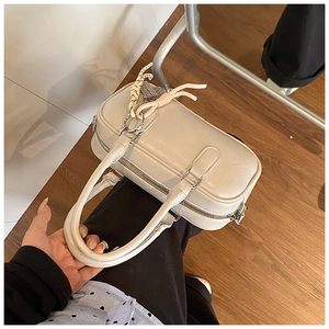 Détail du sac bowling en cuir PU blanc avec doubles poignées et pendentif tressé