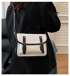 Detailed back view of a black and white messenger bag with retro buckles and shoulder strap