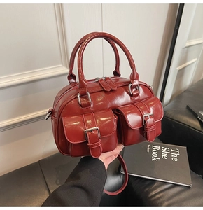 Détail du sac Boston bordeaux en cuir ciré avec poches à boucles et doubles poignées