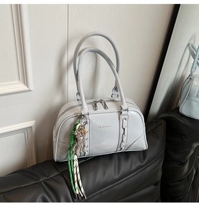 Vue détaillée du sac bowling gris avec fermeture éclair et breloque tissée colorée
