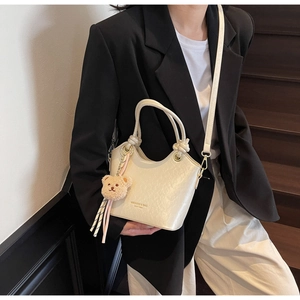 Sac seau chic blanc crème avec charmant ours en peluche marron et détail de logo doré