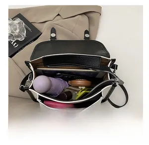 Interior view of black and white messenger bag showing spacious capacity for daily items
