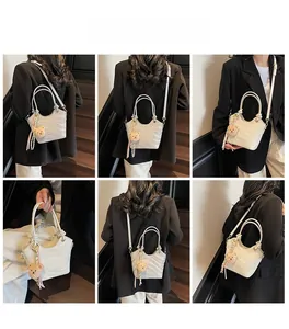 Detail view of wavy textured cream bucket bag with crossbody strap and cute bear charm
