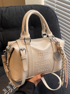 Minimalist cream soft leather Boston bag with embossed lettering and tennis charm