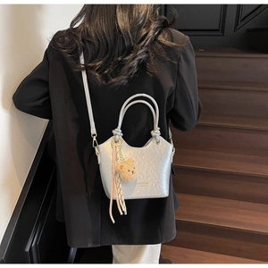 Détail du sac seau argenté avec texture diamant et breloque ours décorative