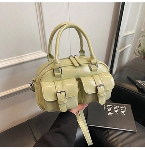 Détail du sac Boston vert avocat en cuir ciré avec boucles métalliques et poches