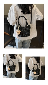 Detail showing wavy textured black crossbody bag with a cute plush bear charm