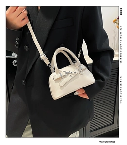 Chic cream mini shell bag with silver hardware on a model wearing a black blazer