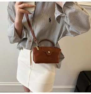 Detailed close-up of a mini brown contrast shoulder bag with golden round snap button