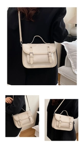 Detail of off-white lychee grain messenger bag with silver hardware and double buckles