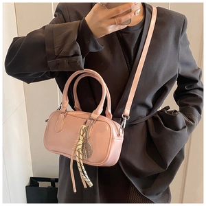 Vue détaillée du sac bowling rose brillant avec bandoulière amovible et pendentif en métal