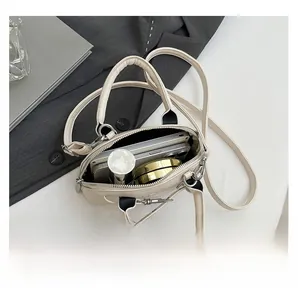 Interior view of cream white shell bag showing capacity for phone and cosmetics