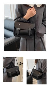 Detail of black lychee texture leather satchel with silver buckles and adjustable strap