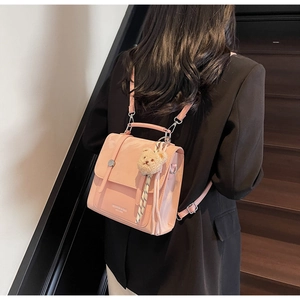 Detail of pink PU leather backpack with silver hardware and cute plush bear charm