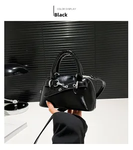 Detail of glossy black shell handbag with silver buckles and adjustable shoulder strap