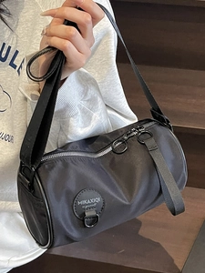 Minimalist black nylon cylinder crossbody bag with fabric strap for casual sports travel
