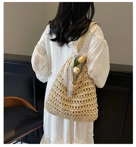 Detail of woven straw tote bag with elegant white lace bow and decorative tulip flower
