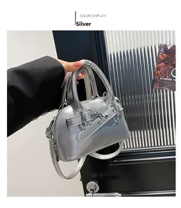 Detail showing the silver mini shell bag with metallic leather and buckle strap detail