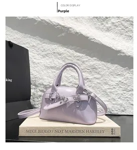Detailed view of a purple mini shell bag with glossy finish and silver metal buckle