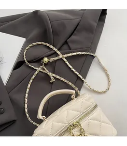 Détail du sac à main matelassé beige avec bandoulière chaîne dorée et poignée chic