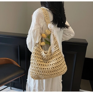Detail of hollow woven straw tote bag featuring white lace bow and floral decoration