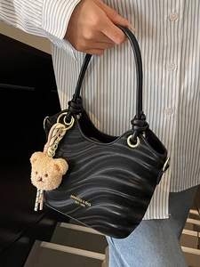 Elegant black wave textured tote bag with golden logo and cute teddy bear pendant
