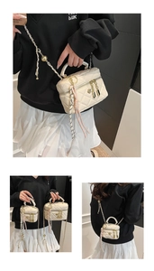 Détail du mini sac boîte matelassé crème avec chaîne dorée et décoration en soie
