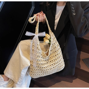 Detail of hollow woven straw tote bag featuring white lace bow and fabric lining inside