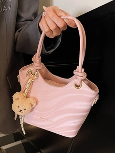 Pink wavy textured bucket bag with top handles and a cute teddy bear charm for women