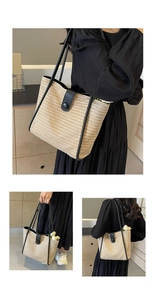 Close-up of woven tote bag with black contrast trim and sleek button closure detail