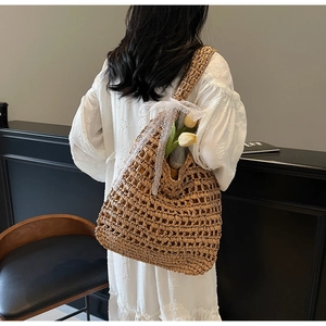 Detailed view of handmade woven straw tote bag with elegant lace bow decoration
