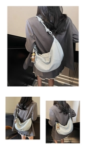 Close-up of soft lychee-patterned leather texture and bear charm on light blue hobo bag