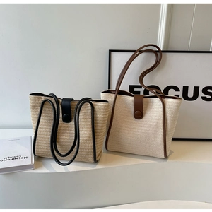 Detail of woven straw tote bags showing natural textures and leather handles in minimalist setting