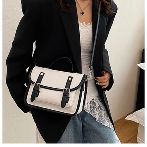 Detail of retro contrast satchel with cream lychee texture and black leather strap