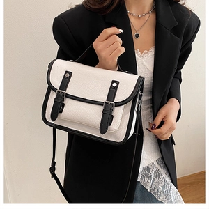 Detail of vintage black and white contrast messenger bag with leather buckle straps