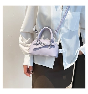 Detail view of a lilac shell bag with silver buckle and removable shoulder strap