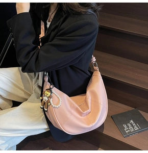Pink crescent tote bag with lychee texture and decorative pearl charm accessory