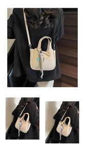 Detailed macro view of beige lychee grain bucket bag with cute cartoon doll charm