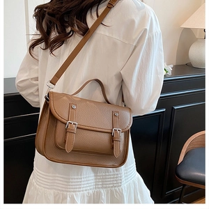 Detail showing the back of a vintage dark brown satchel bag with adjustable shoulder strap