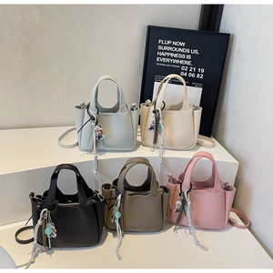 Litchi pattern bucket bags in five colors with tassels and plush charms details