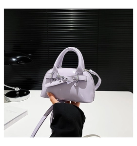 Detail of lavender purple mini shell bag featuring glossy patent leather and silver buckle