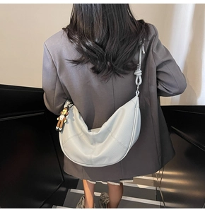 Close-up of light blue lychee pattern leather hobo bag with knotted strap and charm