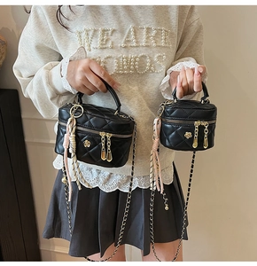 Détail de mini sacs matelassés noirs avec chaîne dorée et foulard en soie décoratif