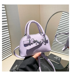 Detail of lavender shell bag featuring decorative belt strap and silver metal lock closure