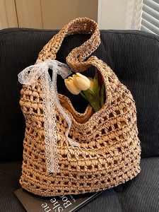 Handwoven straw tote bag with hollow knit design and white lace bow decoration