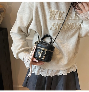 Détail du mini sac matelassé noir avec chaîne dorée et foulard porté par un mannequin